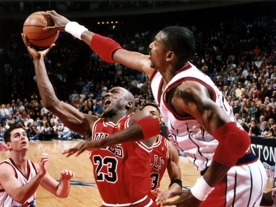 A blocked shot by Hakeem Olajuwon prevents Michael Jordan from taking to the air in a Rockets victory, January 19, 1997, at The Summit.